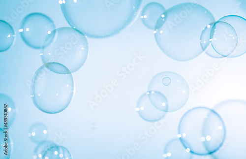 Transparent Blue Soap Bubbles Floating on White Background.