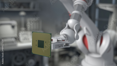 The robot holds a productive processor for a personal computer. Blurry gray background. The concept of future technologies . semiconductors.