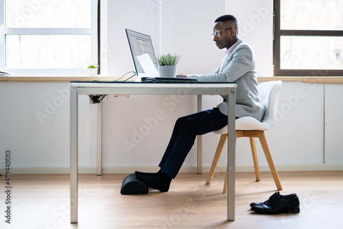 Worker Using Footrest To Reduce Back Strain