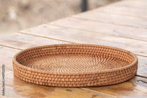 round rattan basket isolated on wooden background.