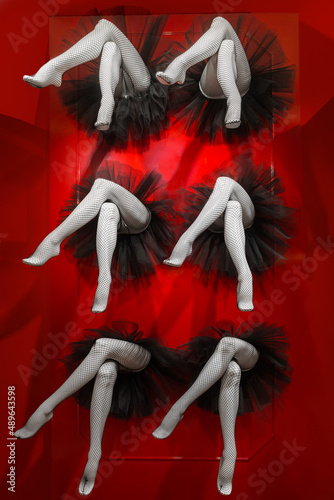 Composition completed by legs of female cabaret dancers dressed in black pantyhose