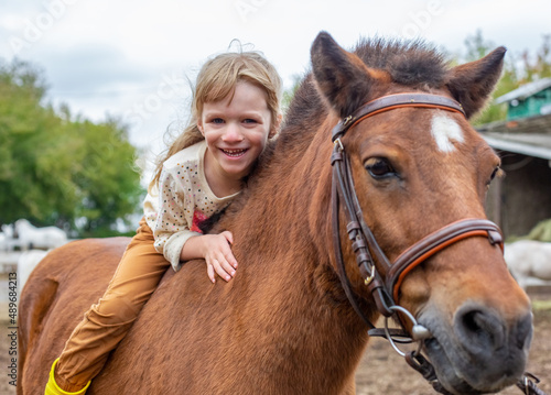 happy little girl riding pony horse bareback and laugh