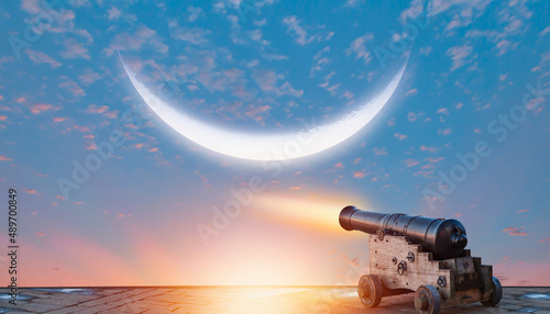 Ramadan kareem concept - Ramadan kareem cannon with crescent moon at amazing sunset
