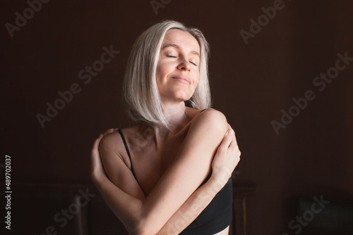 Attractive middle-aged woman enjoys herself and her body, loves herself