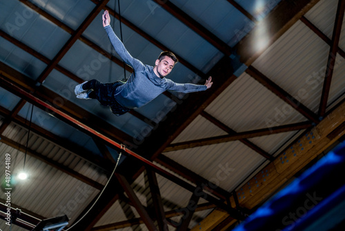 Caucasian man jumping concentrated in trampoline inside the sport center. Mid-air
