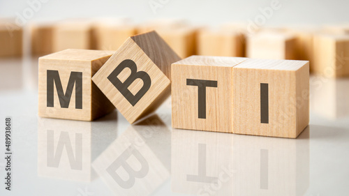 four wooden blocks with the letters MBTI on the bright surface of a gray table, business conceptual word collected of of wooden elements with the letters