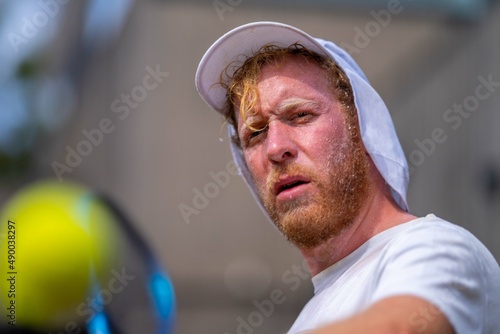 tennis player, swinging at a tennis ball, close up, while sweating, in melbourne australia.