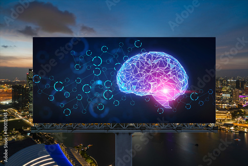 Brain hologram on billboard with Singapore cityscape background at night time. Street advertising poster. Front view. The largest science hub in Southeast Asia. Coding and high-tech science.