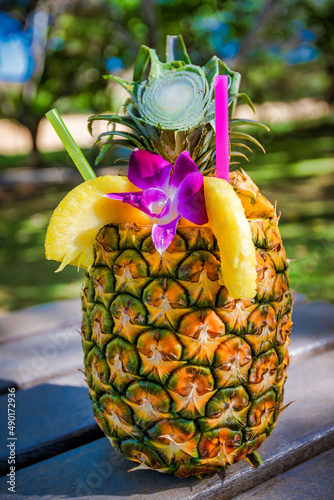Vertical shot of a pineapple cocktail at a beach