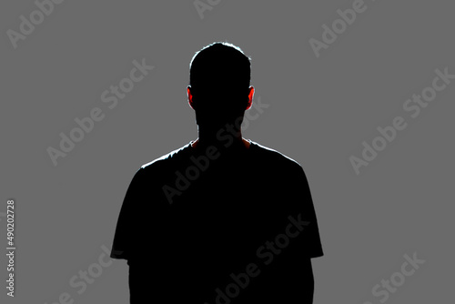 isolated dark male silhouette in the shadow, studio portrait