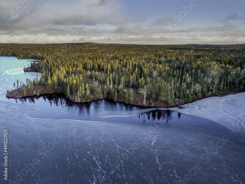 Aerial view of a beautiful frozen lake surrounded by a forest in Halifax, Canada