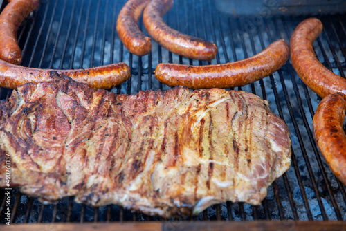 Fatty steak with sausauges on grilled on grid