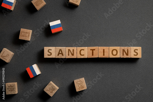 Wooden cubes with financial icons, Russian flag and sanctions. Concept on sanctions in Russia