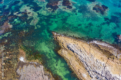 Aerial views of rocky coastal reef popular for swimming in Australia