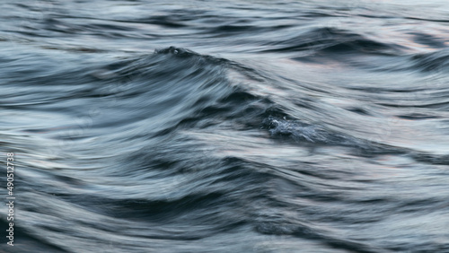 Abstract landscape of wavy turbulent water in wind with silky surface in long exposure and motion blur effect