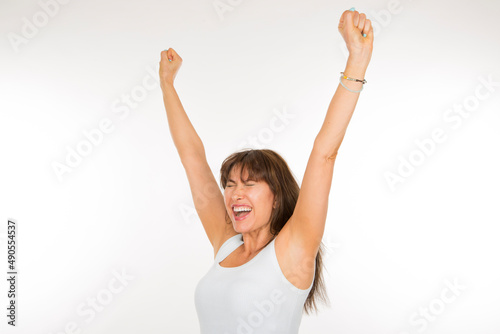 portrait of a cheerful adult woman with her arms raised on a white background