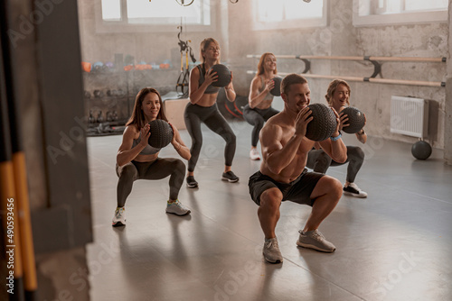 Team of sporty people training in fitness club