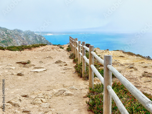 Wooden Fence at Cape Roca in Portugal that leads the eye to the Cascais Coastline shrouded in mist.