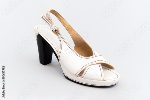 White vintage high-heeled sandals. isolated. Light gray background.