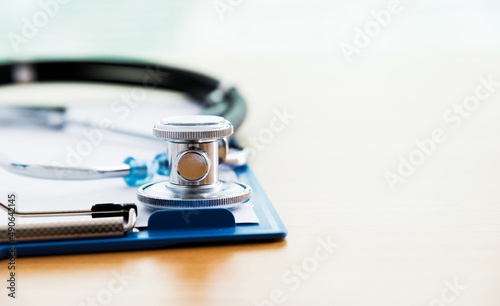 Stethoscope with medical clipboard on table