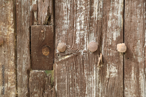 puerta pared de madera antigua vieja marrón agrietada con clavos metálicos y remiendos 4M0A3301-as22