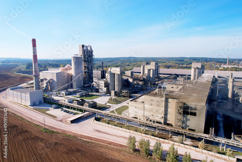 Industrial plant, aerial view. Cement plant with pipes on cement production. Factory with smoke pipe. Chimney smokestack emission. Poor environment. Ecology concept, air and environmental pollution.