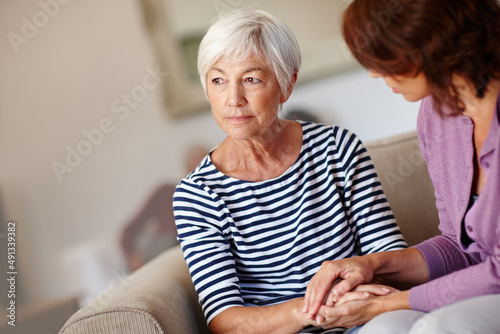 Worried about the future. Shot of a woman sitting beside her elderly mother at home.