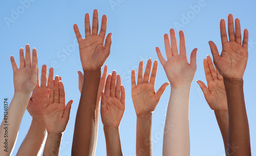 Solidarity through diversity. Cropped shot of a diverse group of people raising their hands.
