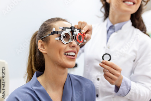 Ophthalmologist examining woman with optometrist trial frame. female patient to check vision in ophthalmological clinic