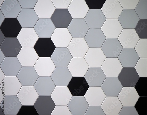 Modern tiled floor with hexagonal tiles. Colors are black,white, light and dark gray randomly arranged. 