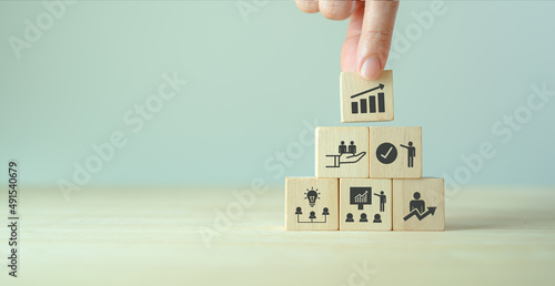 Business, personal development concept. Improving and developing competency, performance. Hand holds wooden cubes with growth icon stading with brainstorm, training, mentor, support and improve icon