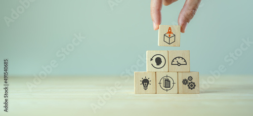 Product development and launching. MVP, minimum viable product concept for lean startup. Analysis and market validation. Hand put wooden cubes with new product launch and learn, build, measure icons.