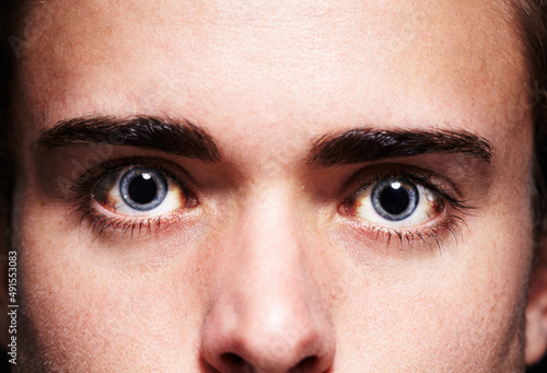High as a kite. Closeup portrait of a young mans face with dilated pupils.