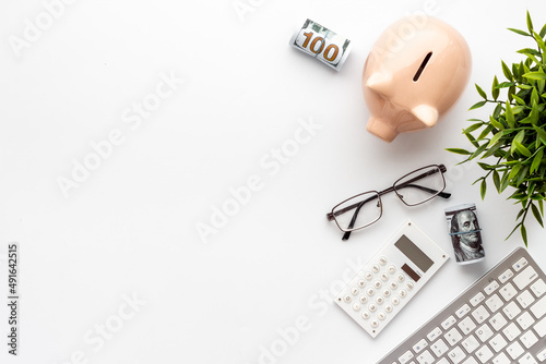 Piggy bank on office table with keyboard and calculator. Financial planning concept