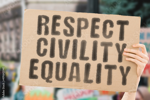 The phrase " Respect civility equality " on a banner in men's hands with blurred background. Racial. Together. Truth. Unity. Us. United. Equity. Activist. Recognition. Fairness. Fair. Integrity. Love