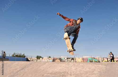 Getting some air. A young man doing tricks on his skateboard at the skate park.