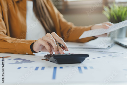 Close up hand of stress asian young employee business woman calculate tax income and expenses, bills, credit card for payment or payday on table at home office. Financial, finance people concept.
