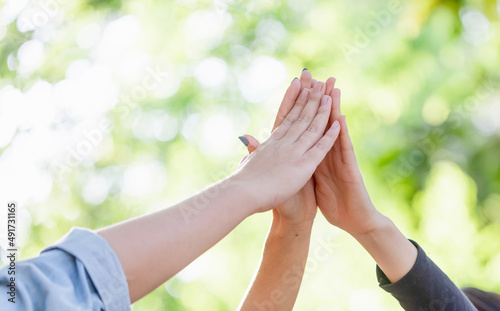 Group girls hands together giving high five feels excited close up focus on stacked palms. celebration and friendship concept