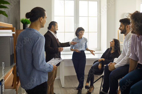 Cheerful and friendly office workers communicate with each other by telling stories and discussing their work during the break. Concept of business, people, teamwork and friendship.