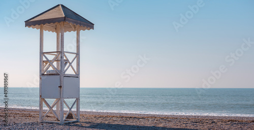 Traveling along the Mediterranean Sea, view of rocky coast of Antalya. White rescue tower at the empty beach. Rescue Cabin on Mediterranean Sea coast landscape