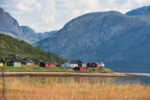 Colorful cottages in fjord landscape, Tanamunningen nature reserve in the mouth of the Teno aka Tana river, Finnmark, Norway