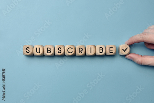 Wooden cubes with the inscription "Subscribe" to them. Internet channel subscription symbol and subscription reminder