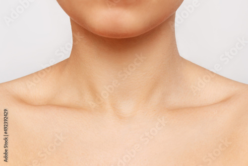 Cropped shot of a young woman's collarbone isolated on a white background. Body care, cosmetology. Soft delicate skin. Close-up