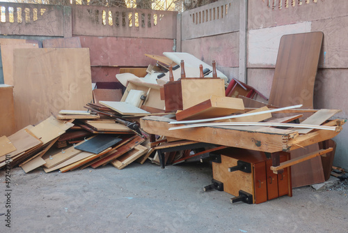 discarded old furniture in the garbage: bedside tables, boards, beds