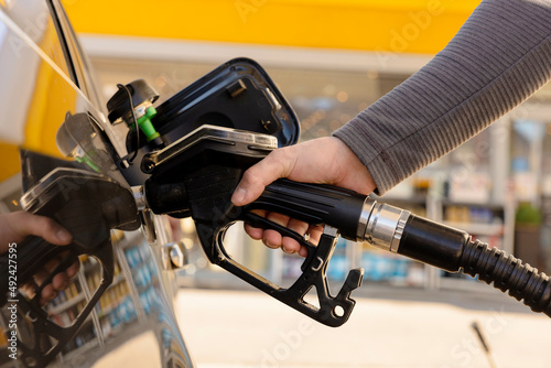 Car refuelling on the petrol station. Man refilling the car with fuel. Close up view. Gasoline, diesel is getting more expensive. Petrol industry and service. Petrol price and oil crisis concept.