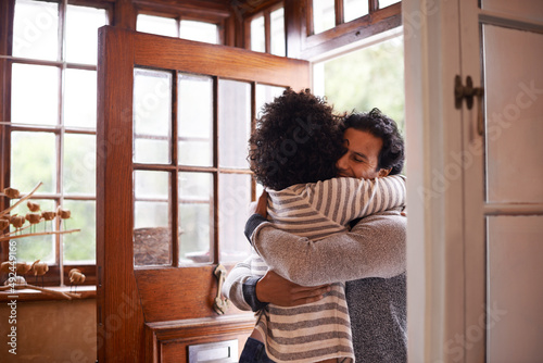 I missed you. Cropped shot of a young woman greeting her husband at the door.