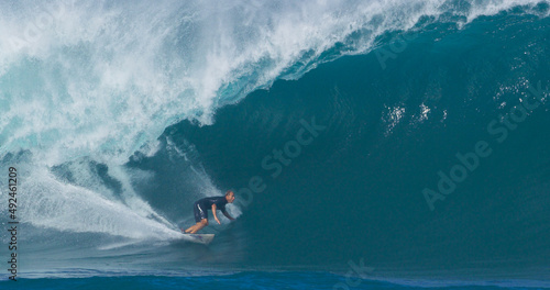 Surfer surfing big ocean barrel tube wave at Pipeline in north shore of Hawaii's Oahu island pro surfer Anthony Walsh