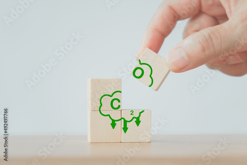 hand hold part of wooden cubes with CO2 emission reduction icon for CO2 emission ,green industries business. Net zero emissions. renewable energy, sustainable technology, ecology solutions concept
