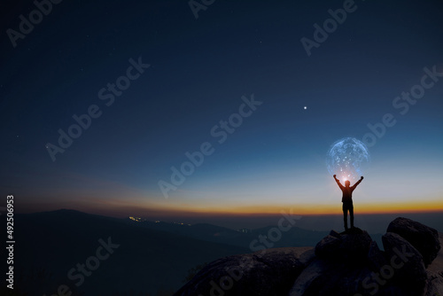Earth in human hands. earth day. energy saving, Man raise hand up on top of mountain with sunrise sky and blue sky background, freedom travel adventure and feel good concept.