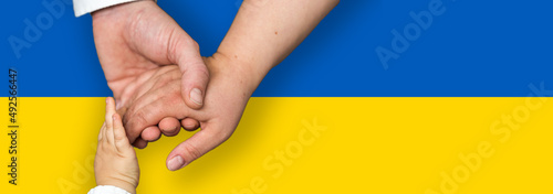 Flagge der Ukraine mit den Händen einer Familie mit einem Kind